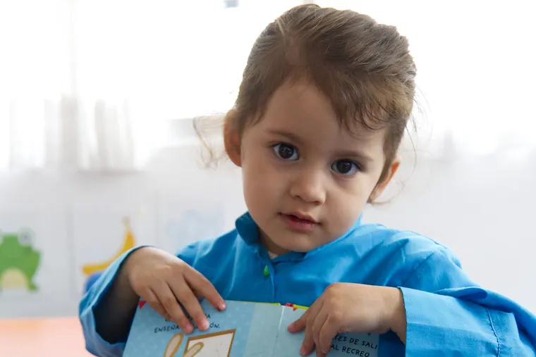 Bebés, niñas y niños de maternal jugando con su maestra